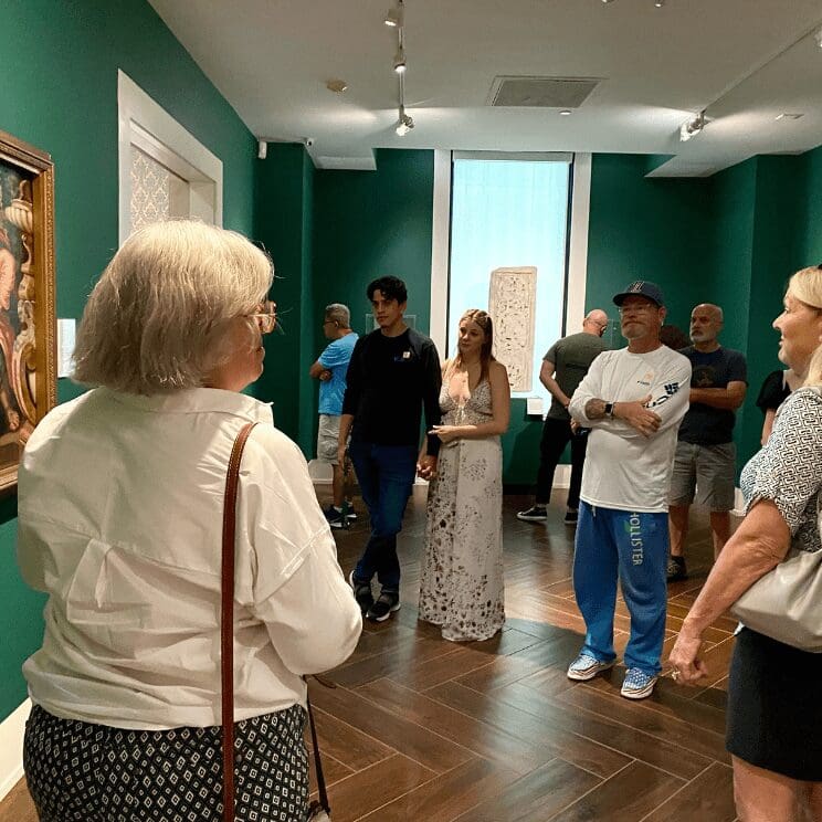 Plan your visit to the MFA. Image: A group of people looking at art in a museum.